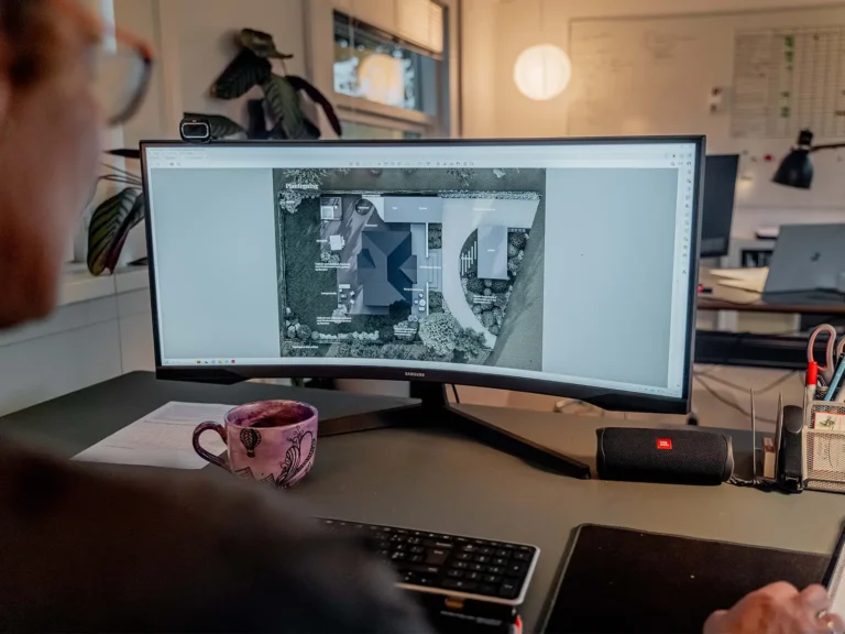Havearkitekt designer målfast haveplan foran computer